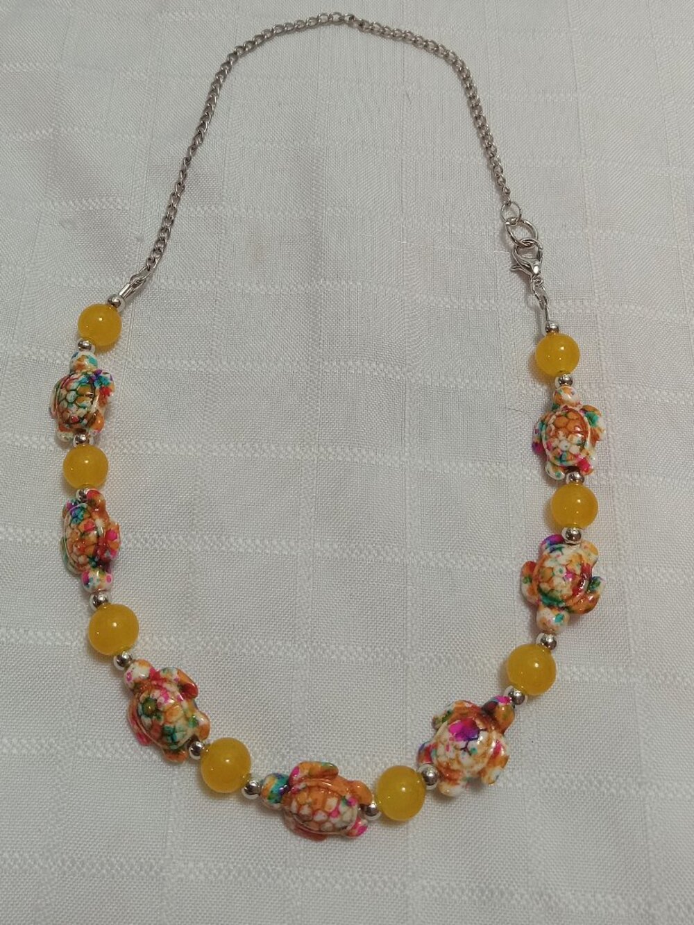 Pretty handmade necklace with little turtles and glass bead